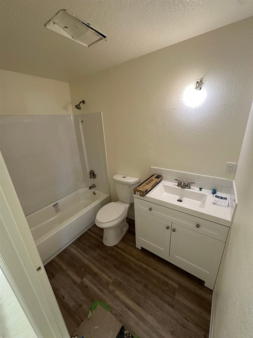 Finished bathroom with a new tub, toilet, and vanity