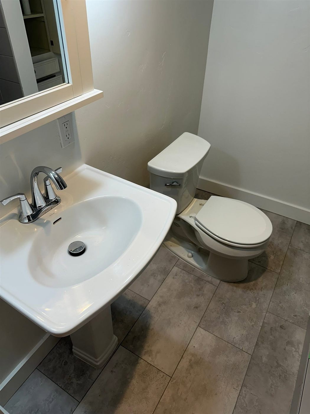 Pedestal sink and toilet in a finished bathroom
